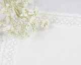 White flowers with lace ribbon placemat on a white background