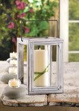 Decorative lantern with a candle on a wooden surface outdoors