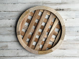 Wooden basket plate charger with white cylindrical items on a light wooden background