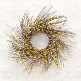 Decorative wreath with branches and yellow accents on a textured white background