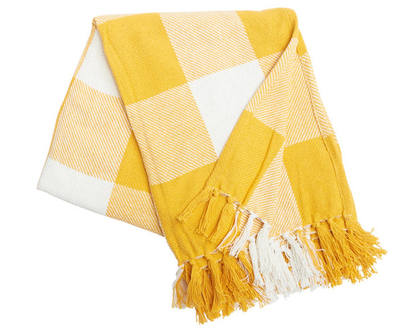 Yellow and white checkered blanket with fringes on a white background