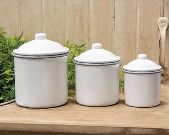 White kitchen canisters with gray trim along the top next to the lid