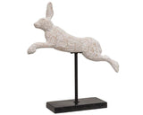 A front-facing view of a 14-inch whimsical jumping bunny rabbit wooden pedestal showcasing its hand-distressed white paint and rectangular black metal base.