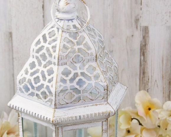 Distressed white ornate lantern

Add classic style your shabby farmhouse decor with this white lantern that features a distressed gold design. Made of iron, this large lantern is perfect for a fireplace hearth and would look just as good on a covered porch or patio.

Materials:
Iron, glass

Dimensions:
7 1/2” wide x 16” tall 