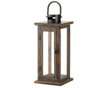 A tall, square decorative candle lantern crafted from dark brown stained wood, featuring clear glass window inserts, a metal top ventilation cap with a hanging loop, and an antique-style front door latch.